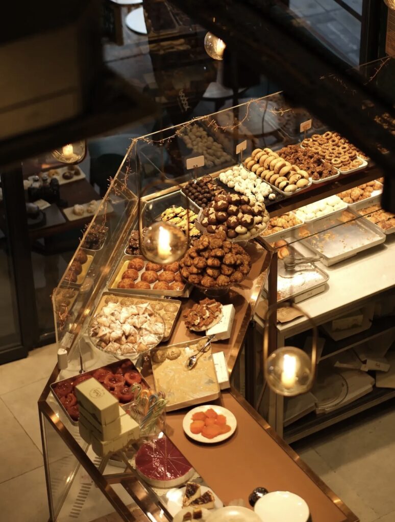 High-angle view of the Ceviz Ev Yapımı counter showing pumpkin dessert (kabak tatlısı), savory cookies, and gift boxes.